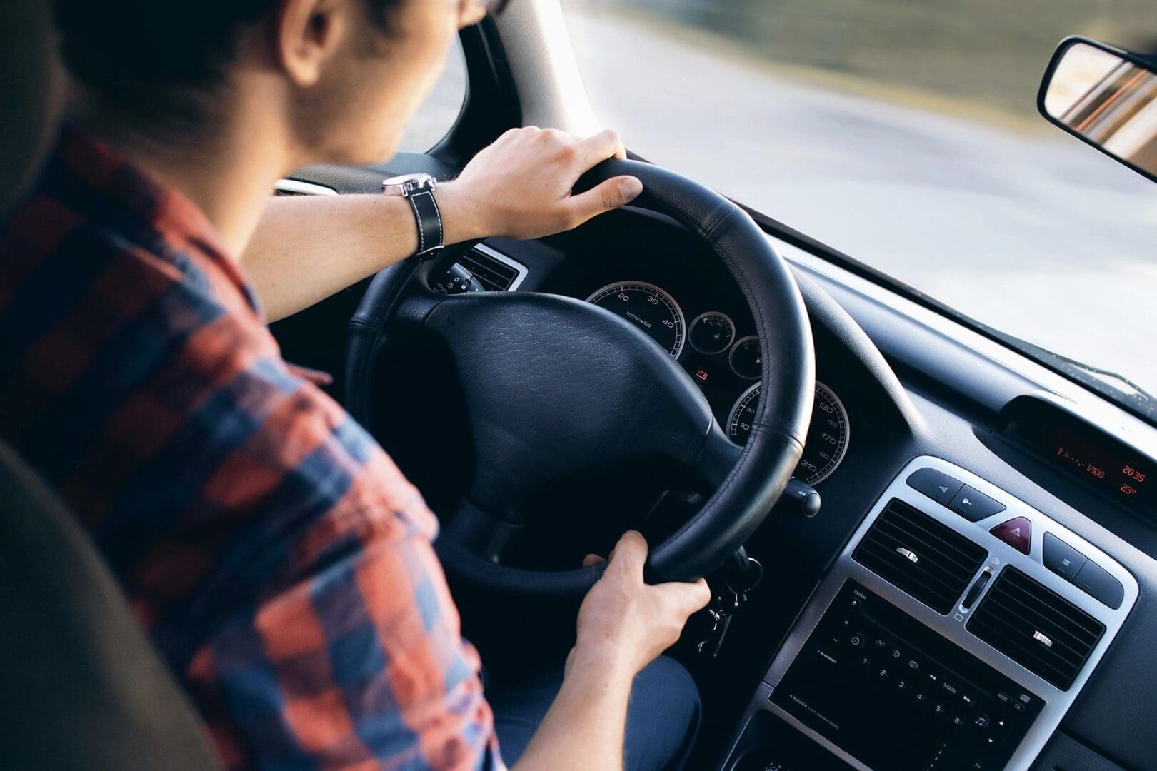 A person driving a car in the road