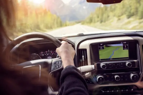 A person driving in the driver 's seat of a truck.